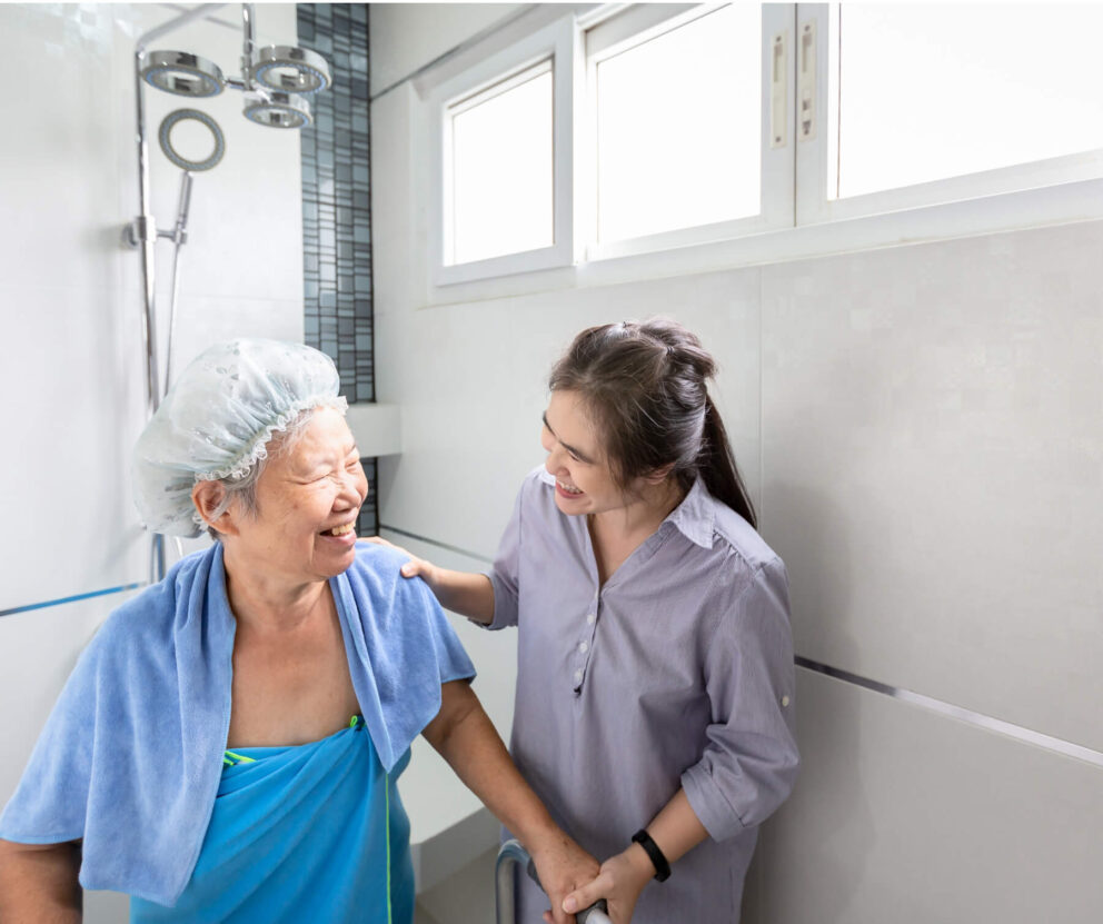 Support worker helping elderly woman in the shower